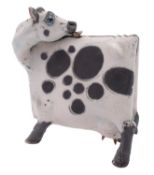*Lawson E Rudge [b 1936] a raku fired cow of angular form modelled licking its back,