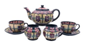 A Moorcroft part tea service in the Violets pattern, comprising a teapot and cover,