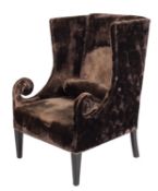 A velvet upholstered wing armchair, by Designers Guild, with Andrew Martin velvet