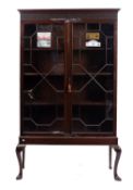 A mahogany and glazed cabinet on stand,