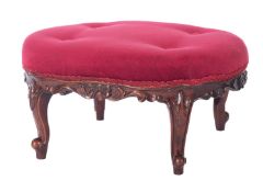 A carved walnut oval low stool in Victor