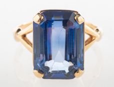 A 9ct gold cocktail ring, set with a rectangular-cut blue stone, 'V' split shoulders, UK hallmark,