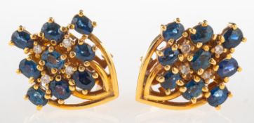 A pair of sapphire and diamond cluster earrings, each set with nine oval-cut sapphires,