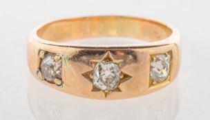 A three stone diamond ring, of band form and set with three old-cut diamonds,