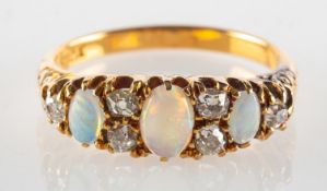 An antique opal and diamond ring, set with three oval opal cabochon's,