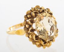 A vintage citrine cocktail ring, claw set with an oval-cut citrine, with a floral surround,