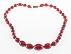 A red cherry 'amber' type bead necklace, a graduated string of red cherry 'amber' type beads,