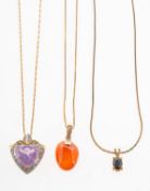 A group of three pendants with chains, including a pendant with a carnelian stone drop,