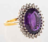 An 18ct gold amethyst and diamond cluster ring, claw set with an oval mixed-cut amethyst,