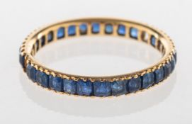 A full eternity ring, set with square-cut blue stones (two missing), unmarked, size M1/2, 1.6grams.