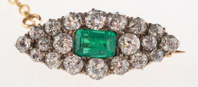 An Edwardian emerald and diamond brooch, of navette form, set centrally with an emerald-cut emerald,