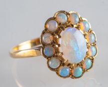 A 9ct gold opal cluster ring, claw set to the centre with an oval opal cabochon,
