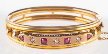 An Edwardian diamond and ruby bangle, openwork design hinged bangle,