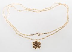 A rice krispie pearl necklace with flower pendant, a long string of rice krispie pearls,