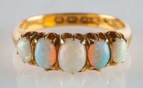An 18ct gold five stone opal ring, set with five graduated oval opal cabochon's, UK hallmark,