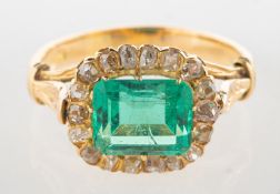 An emerald and diamond ring, claw set east to west with a rectangular-cut emerald, emerald approx.