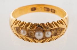 An antique pearl ring, an ornately carved ring set with seed pearls,