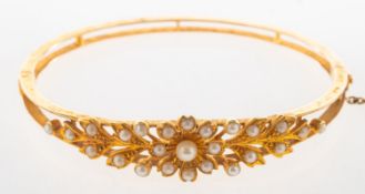 A Victorian pearl bangle, of floral and foliate design, set with small pearls and split pearls,
