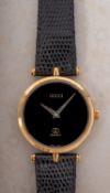 A Gucci 2000M gold-plated wristwatch the round black dial signed Gucci and having the Gucci logo,