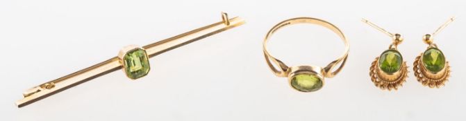 A group of peridot set jewellery, including a 9ct gold ring set with an oval-cut peridot,