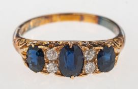 A sapphire and diamond ring, a 'gypsy' style scroll carved ring set with three oval-cut sapphires,