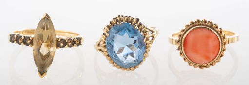 A group of three gem-set rings,
