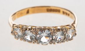 An 9ct gold five stone ring, claw set with five graduated circular-cut paste stones,