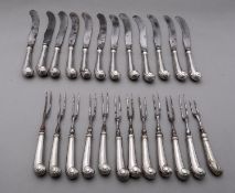 A set of George III silver pistol grip and acanthus leaf handled table knives with steel scimitar