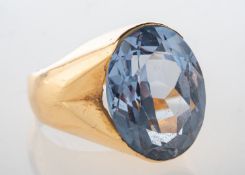 A cocktail style ring, set with an oval-cut blue stone, possibly a synthetic spinel,