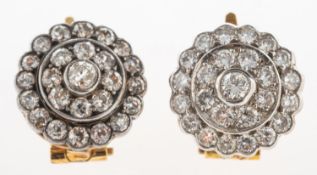 A pair of diamond earrings, each of flowerhead form and set with brilliant-cut diamonds,