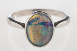 A modern black opal ring, collet set with a black oval opal cabochon, opal measures approx. 10.