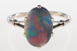 A black opal ring, claw set with a black oval opal cabochon, 'V' split shoulders,