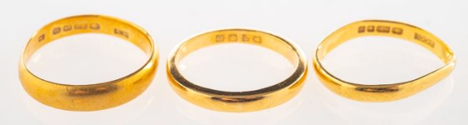 Three 22ct gold bands, including a 22ct gold wedding band, UK hallmark, size M to M1/2, 4.