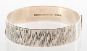 A mid-century silver bangle, by Bracelon, of textured finish, hinged , UK hallmark, Birmingham,