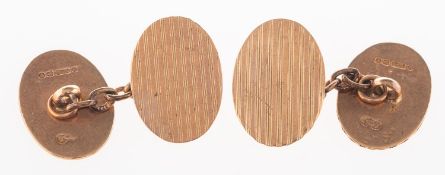 A pair of 9ct rose gold cufflinks, of oval form with engine turned engraving to both panels,