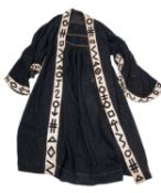 A black wool masonic style cloak, trimmed with white silk embellished with stylised symbols,
