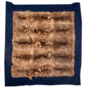 An early 20th century racoon skin rug, on a blue felt ground,