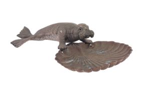 A late 19th/ early 20th century novelty ashtray in the form of a silver plated walrus resting on a