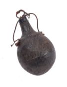 A leather covered wooden powder flask with stopper.