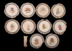 A late 19th century set of ten silk and lace circular place settings decorated in the manner of