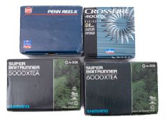 A collection of four fishing reels.