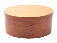 A cherry wood oval box in Shaker style,