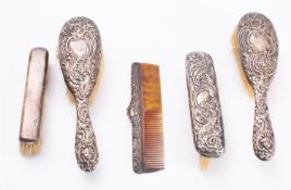 Four various silver backed brushes and a