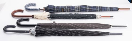 A group of four walking umbrellas, inclu