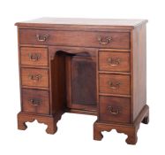 A mahogany kneehole desk in George II style, 19th century; the top with moulded edges,