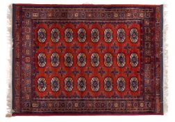 A Turkish rug, of Turkoman design, the rust field with three rows of quartered medallions,