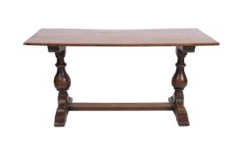 An oak refectory table in 16th Century style, circa 1900; the rectangular top on shaped bearers,