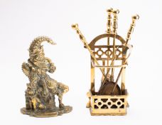 A brass doorstop cast as Mr Punch, early 20th century; portrayed as seated, with shaped base,
