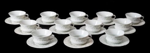 Twelve Meissen porcelain thistle shaped cups and saucers both embossed with a series of arches,