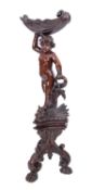 A Continental carved and stained wood, probably limewood, figural jardiniere stand,